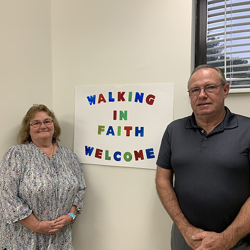 Walking in Faith teachers standing by welcome sign