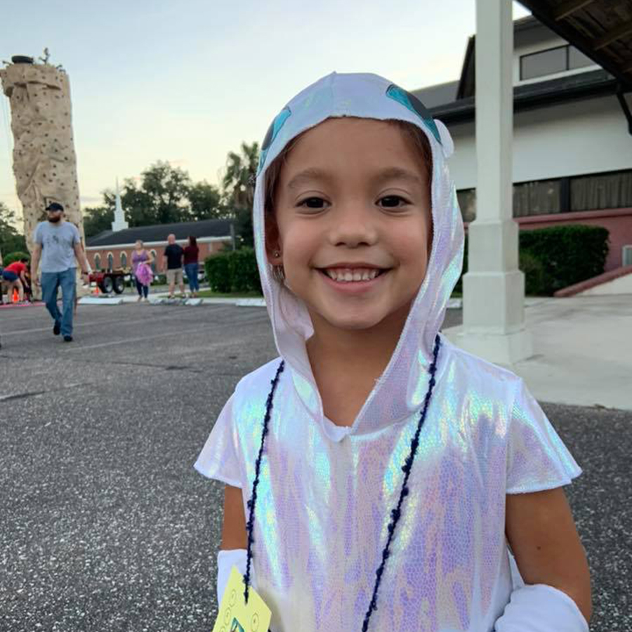 Costumed child in front of rock climbing wall